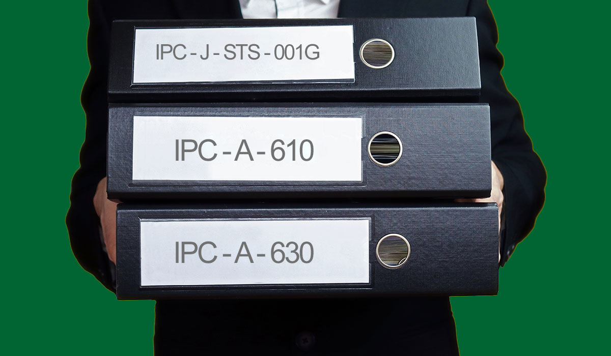 Person holder 3 sorte mapper med IPC standard mærker. IPC-A-610, IPC-A-630 og IPC-J-STS-001G